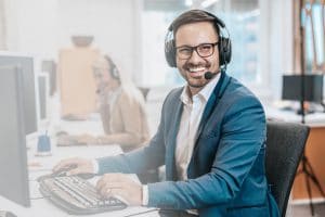 Ein lächelnder Mann mit Headset, Symbolbild für die HV13 Immobilien-Verwaltung